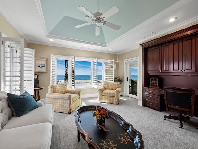 living room featuring a water view, crown molding, and a tray ceiling