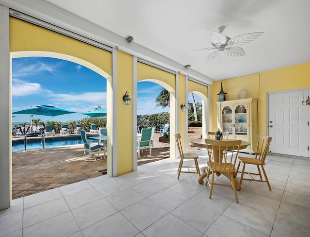 sunroom / solarium featuring a ceiling fan