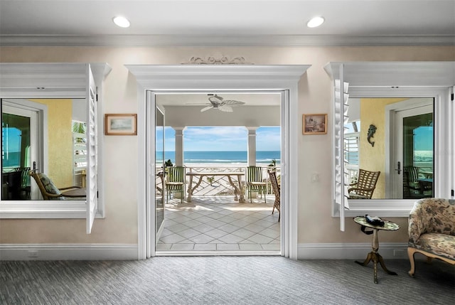 doorway to outside featuring a wealth of natural light, carpet, and crown molding