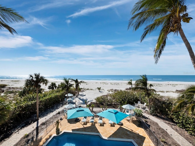 property view of water with a view of the beach and fence