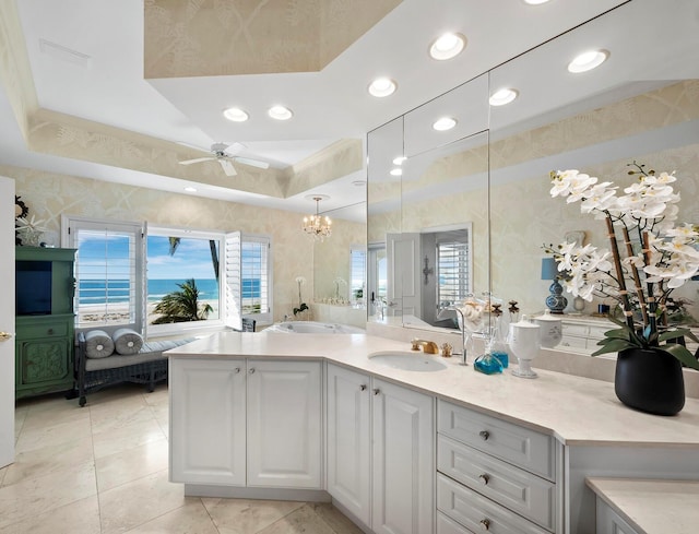 full bath featuring recessed lighting, ceiling fan, vanity, and a tray ceiling