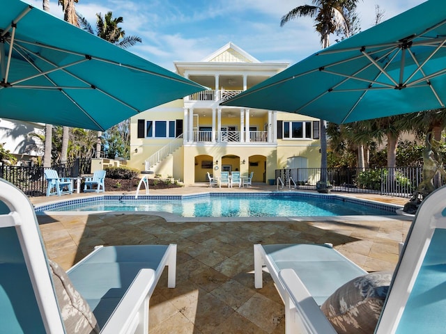 pool featuring a patio, stairway, and fence