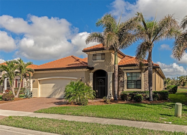 mediterranean / spanish house with a garage and a front lawn