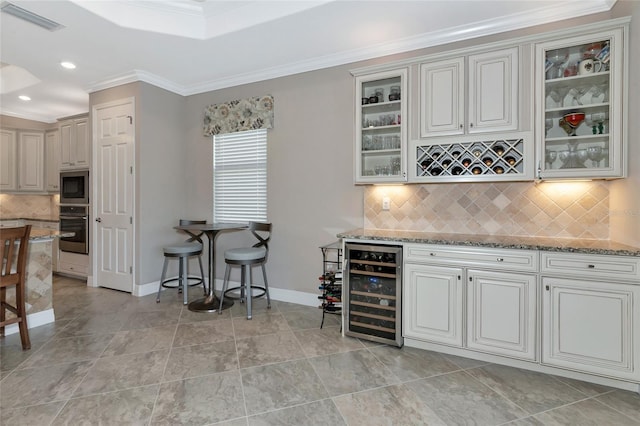 kitchen featuring decorative backsplash, beverage cooler, stainless steel appliances, and light stone counters