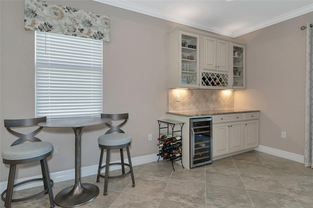 bar with wine cooler, ornamental molding, tasteful backsplash, light stone counters, and white cabinetry