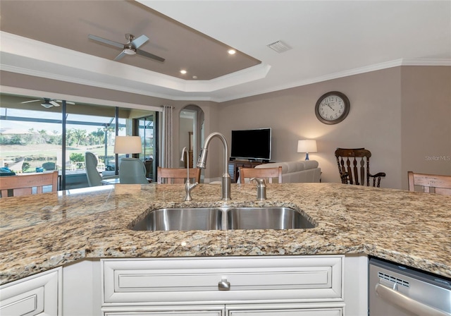 kitchen with sink, a raised ceiling, light stone counters, stainless steel dishwasher, and crown molding