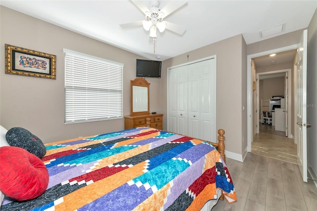 bedroom featuring multiple windows, light hardwood / wood-style floors, a closet, and ceiling fan