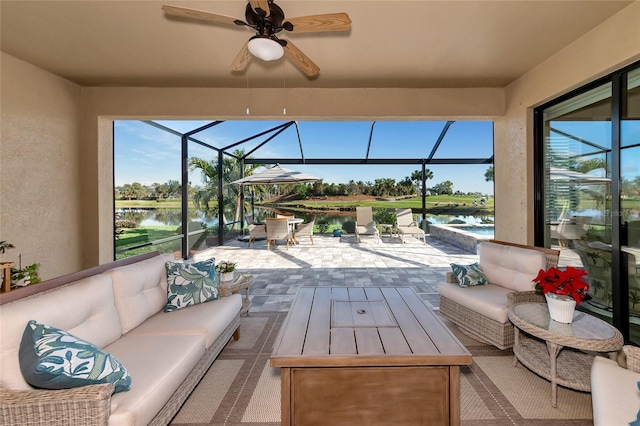 sunroom / solarium with a water view and ceiling fan