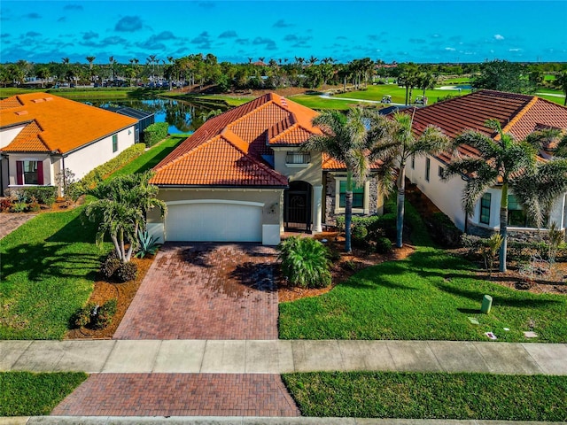 view of front of property featuring a front lawn, a water view, and a garage