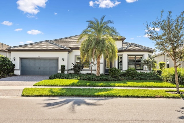 mediterranean / spanish house with a front yard and a garage