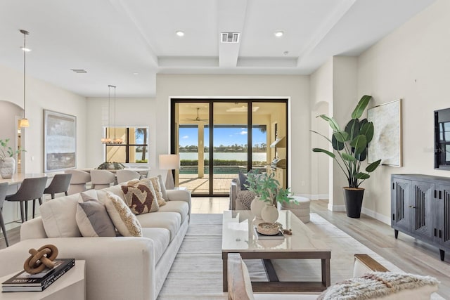 living room with light hardwood / wood-style floors and a notable chandelier