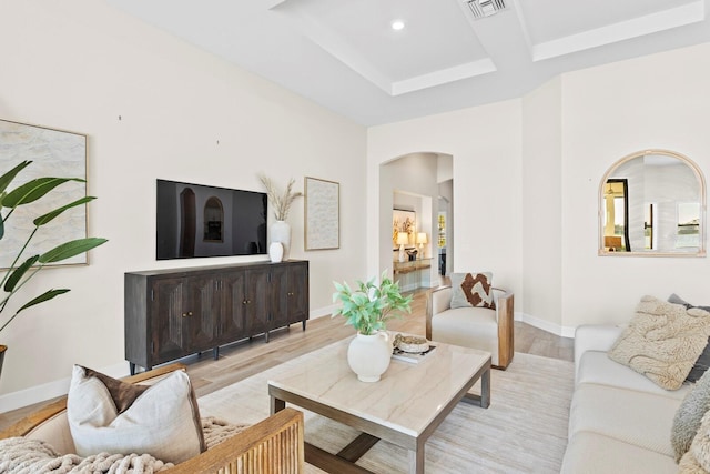 living room featuring beamed ceiling, coffered ceiling, and light wood-type flooring