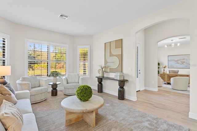 living room with a chandelier and light hardwood / wood-style floors