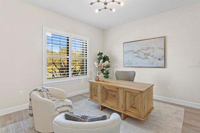 office area featuring a notable chandelier and light wood-type flooring