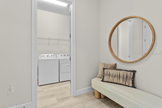 interior space with washing machine and dryer and light hardwood / wood-style floors