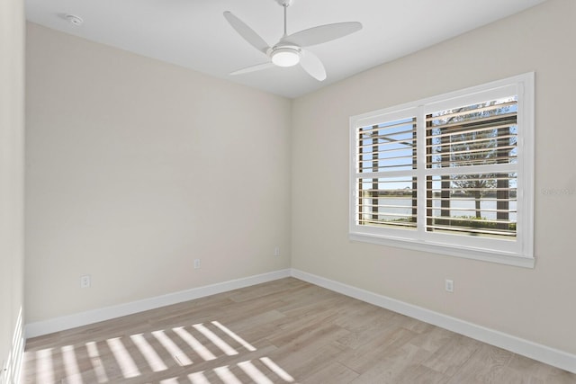 spare room featuring light wood-type flooring, a wealth of natural light, and ceiling fan