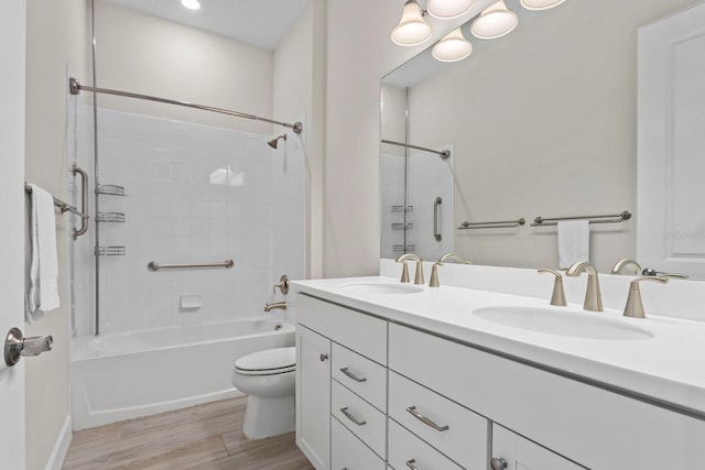 full bathroom with shower / tub combination, vanity, wood-type flooring, and toilet