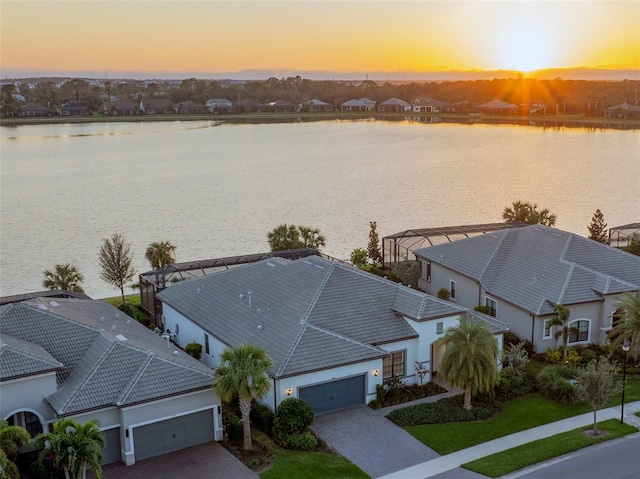 aerial view at dusk featuring a water view