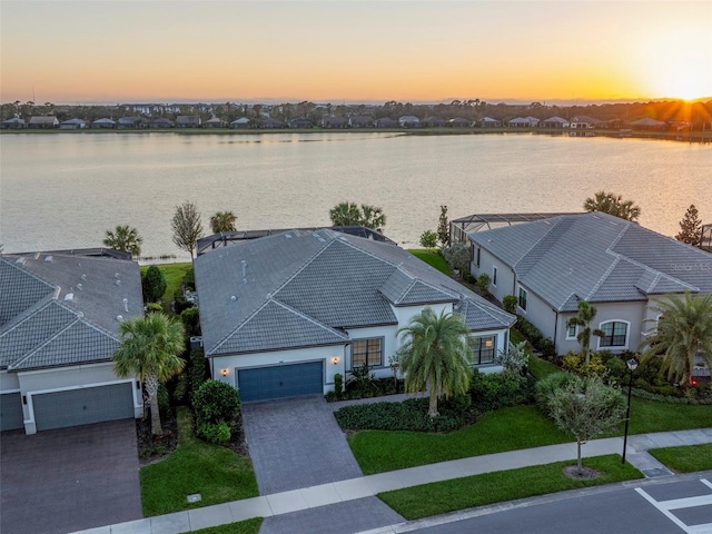 aerial view at dusk featuring a water view