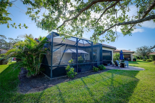 back of house with a lawn, a patio area, and a lanai