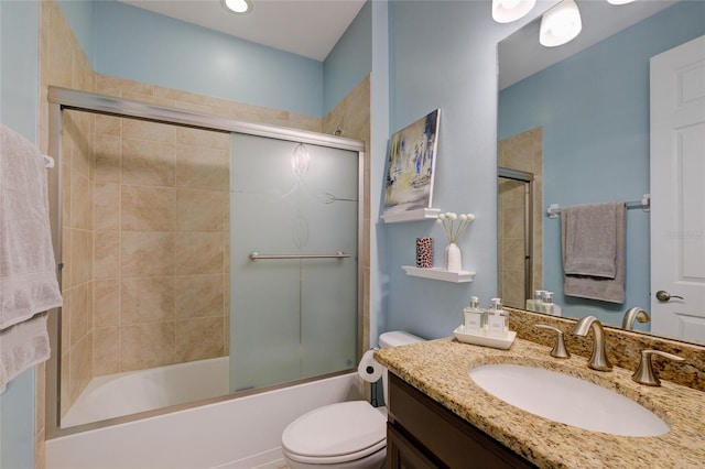 full bathroom with combined bath / shower with glass door, vanity, and toilet