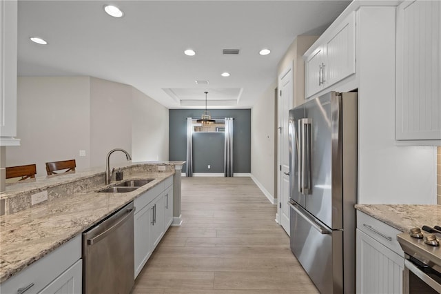 kitchen featuring white cabinets, sink, light stone countertops, and stainless steel appliances