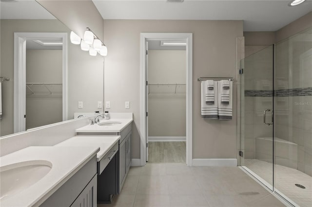 bathroom with tile patterned floors, vanity, and walk in shower