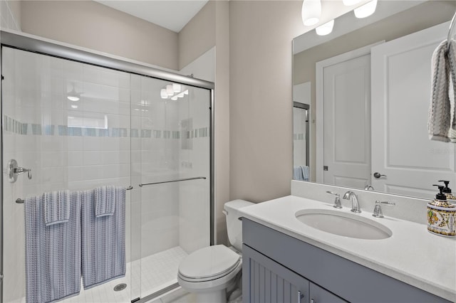 bathroom with toilet, an enclosed shower, and vanity