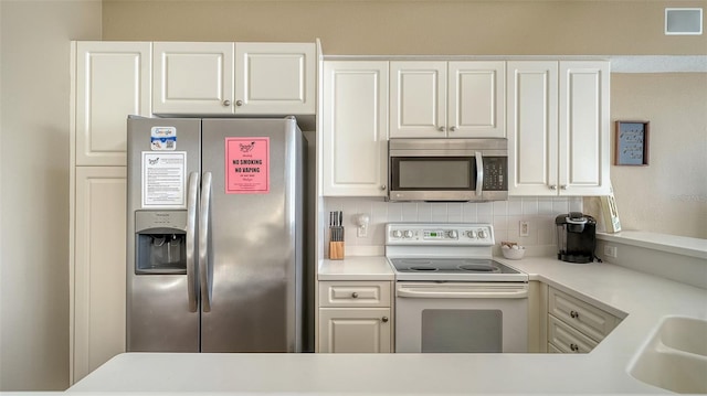 kitchen featuring sink, white cabinetry, stainless steel appliances, and tasteful backsplash