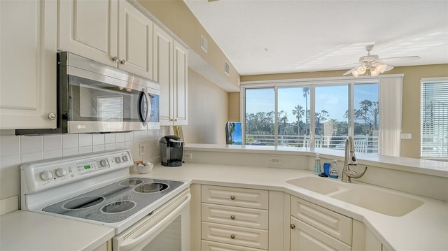 kitchen featuring decorative backsplash, electric range, a wealth of natural light, and sink