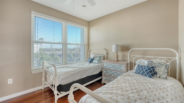 bedroom with ceiling fan, dark hardwood / wood-style flooring, and multiple windows