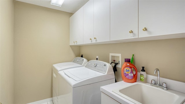 laundry area featuring sink, cabinets, and independent washer and dryer