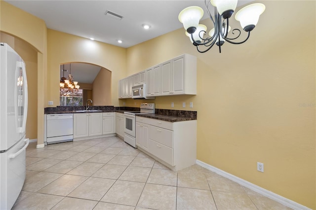 kitchen featuring white cabinetry, decorative light fixtures, white appliances, and an inviting chandelier