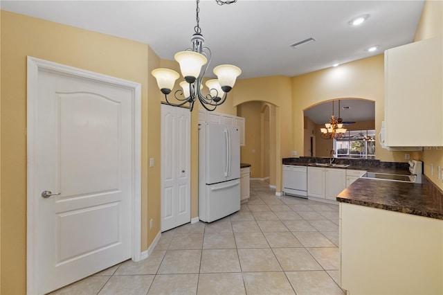 kitchen featuring white appliances, an inviting chandelier, sink, decorative light fixtures, and white cabinetry