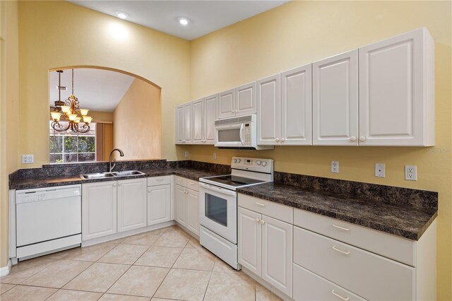 kitchen with white appliances, sink, pendant lighting, a notable chandelier, and white cabinetry