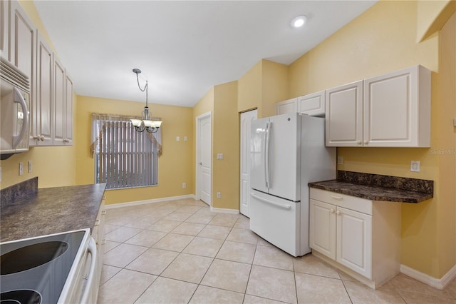 kitchen featuring white appliances, hanging light fixtures, light tile patterned floors, a notable chandelier, and white cabinetry