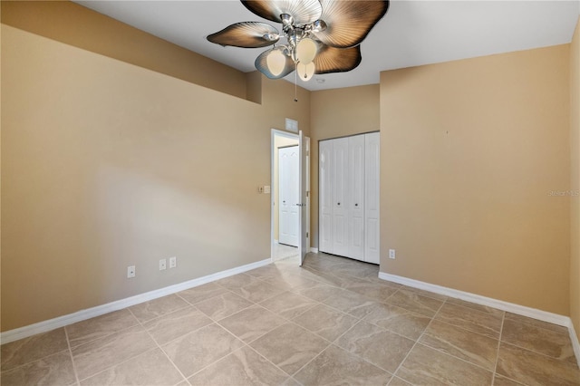 unfurnished bedroom with ceiling fan, a towering ceiling, and a closet