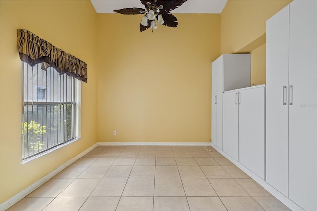 tiled empty room featuring ceiling fan