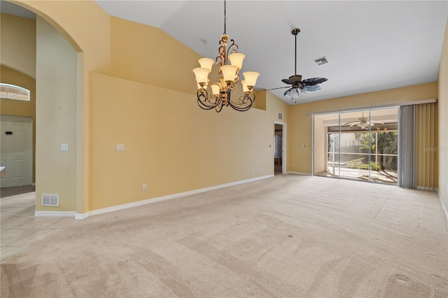 carpeted empty room featuring ceiling fan with notable chandelier and lofted ceiling