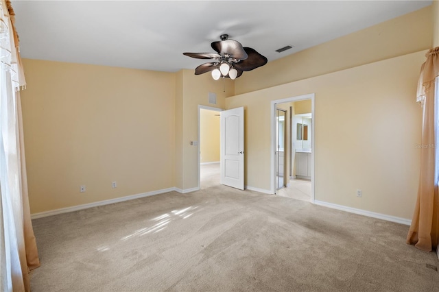 unfurnished bedroom featuring ceiling fan, light carpet, and connected bathroom