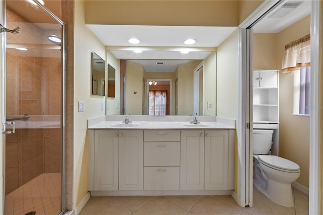 bathroom featuring tile patterned floors, vanity, toilet, and a shower with door