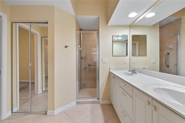 bathroom featuring tile patterned floors, vanity, and a shower with shower door