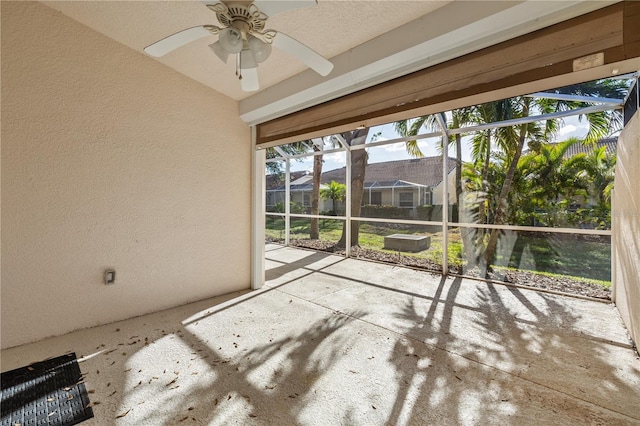 unfurnished sunroom with ceiling fan and vaulted ceiling