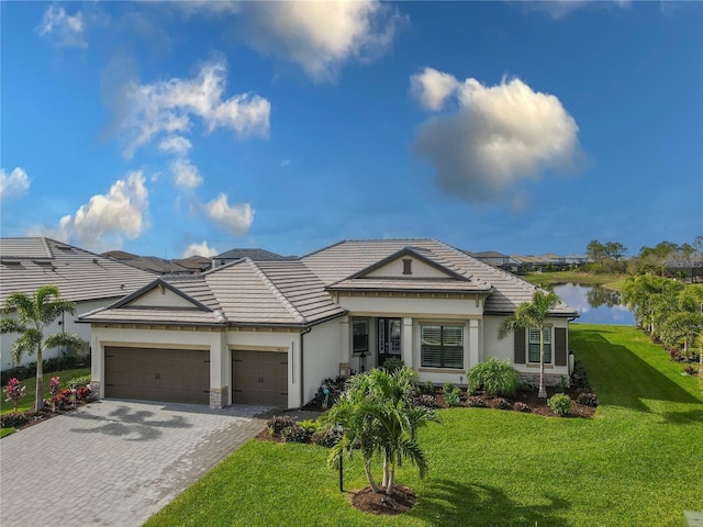 view of front of home with a water view, a garage, and a front lawn