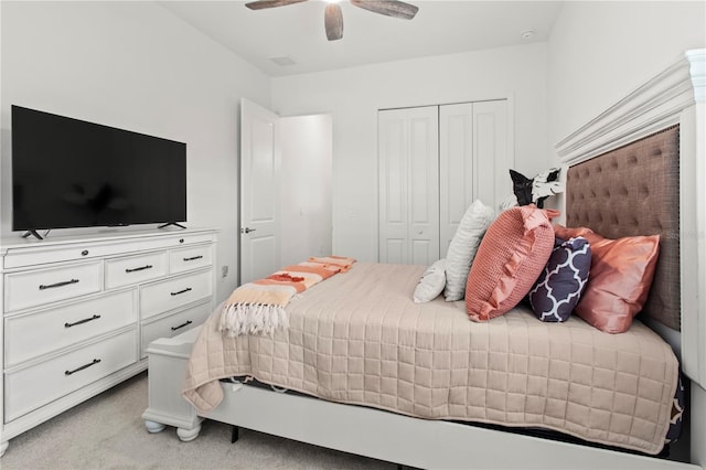 carpeted bedroom with ceiling fan and a closet