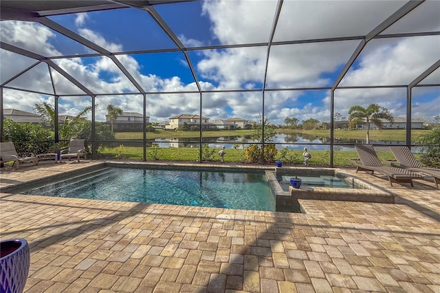 view of swimming pool with glass enclosure, a patio area, a water view, and an in ground hot tub