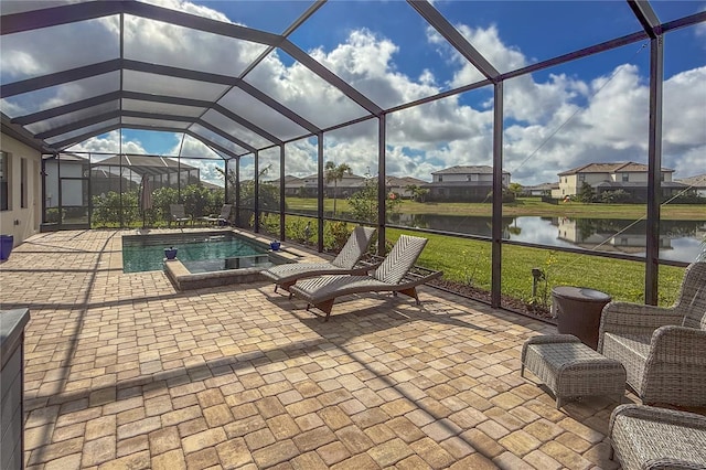 view of swimming pool featuring a yard, a patio, a water view, and glass enclosure