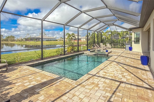 view of pool featuring glass enclosure, a patio area, and a water view