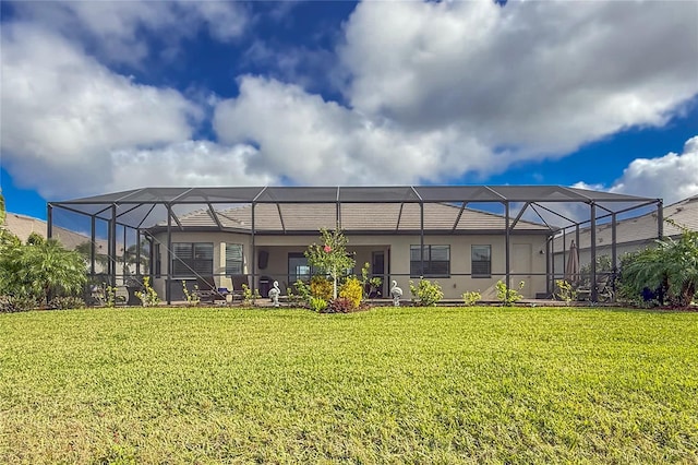 rear view of property with glass enclosure and a yard