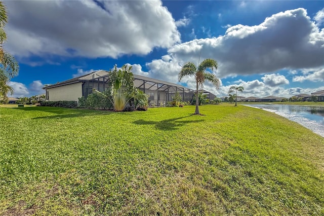 view of yard with a lanai and a water view